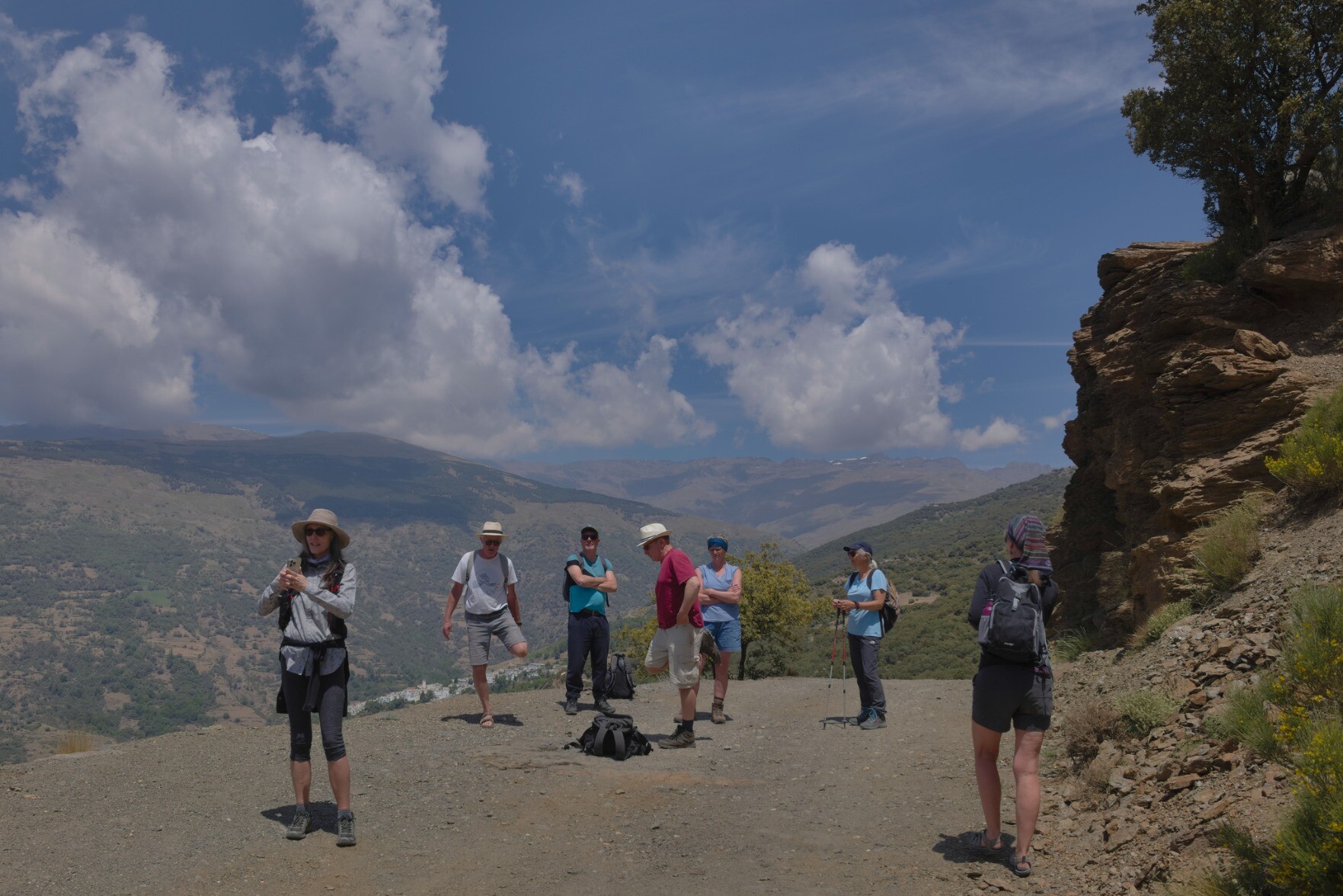 A group of hikers at the Tajo de Angel with clouds over the Sierra Nevada that rise behind