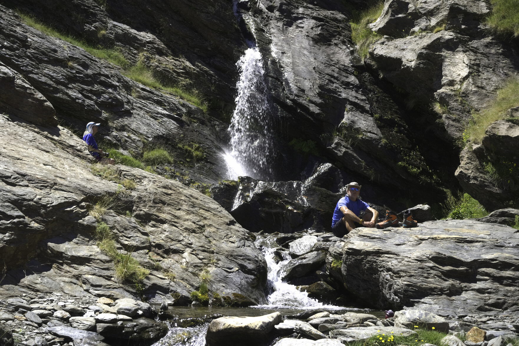 Some hikers relax by a waterfall