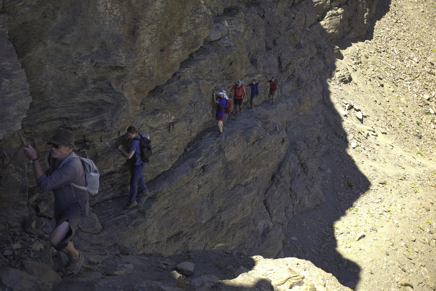 The "Paso de los Guias" ... a group of hikers crossing a steep rock wall holding onto a fixed chain for safety